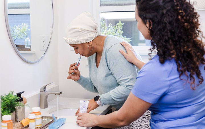 Caregiver with patient brushing teeth.