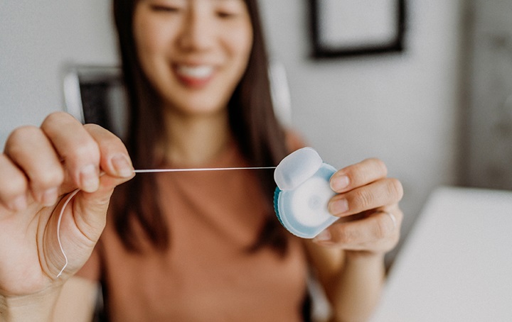 Woman getting strand of floss