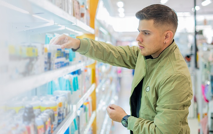Man picking out toothpaste in store