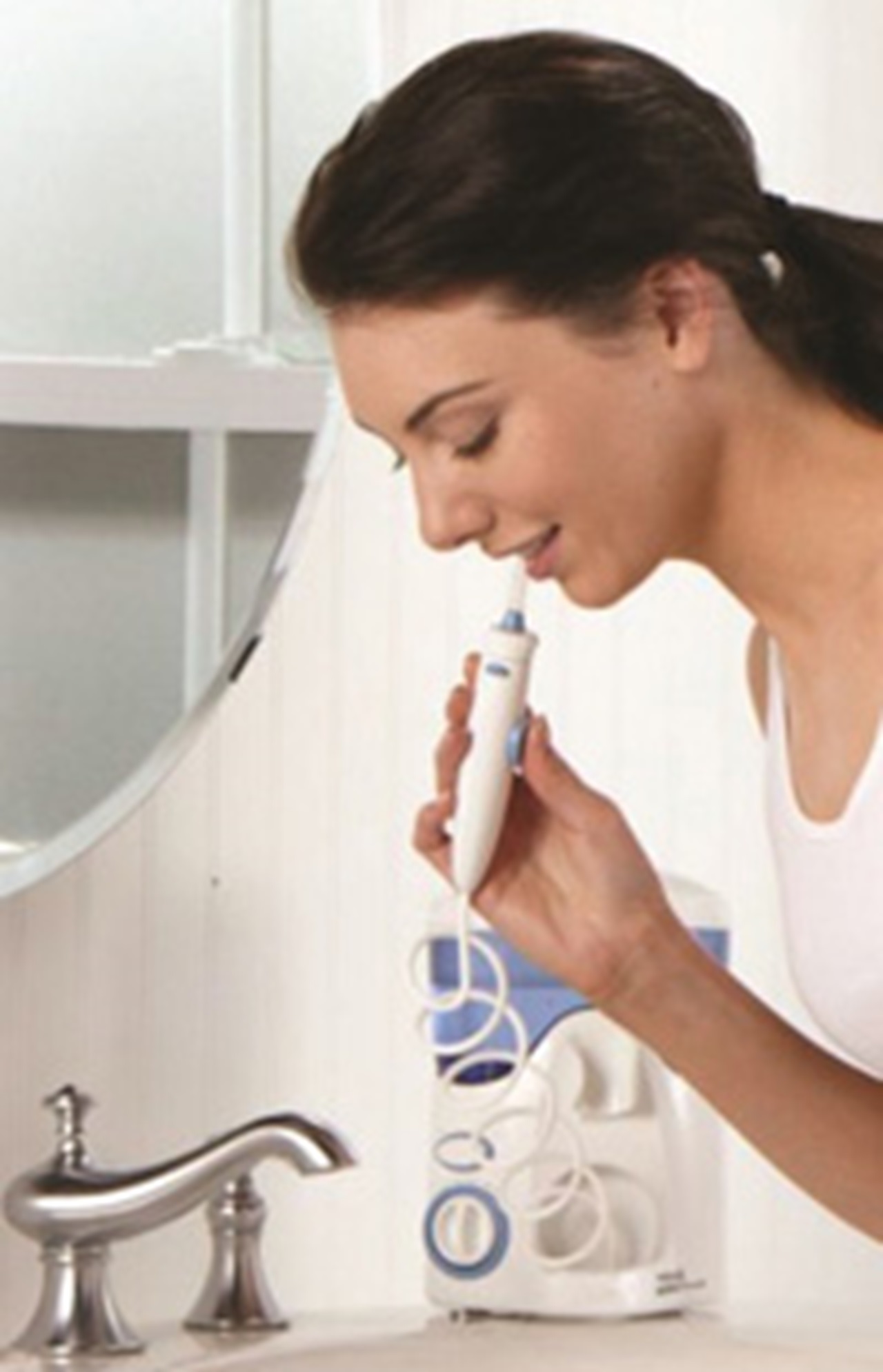 Woman using ADA-accepted Waterpik water flosser.