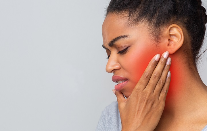 Woman with hand on jaw with dental pain