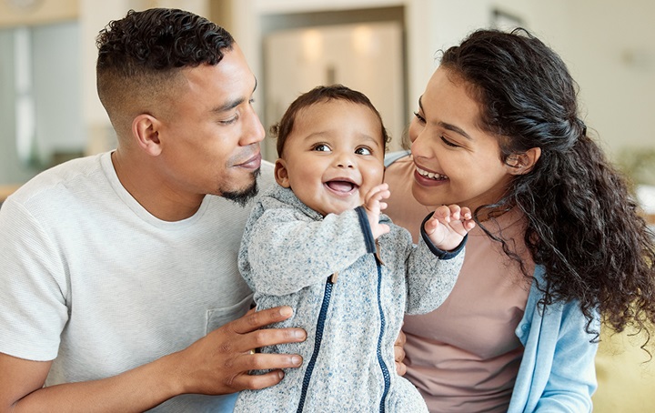 Father, baby, and mother all smiling