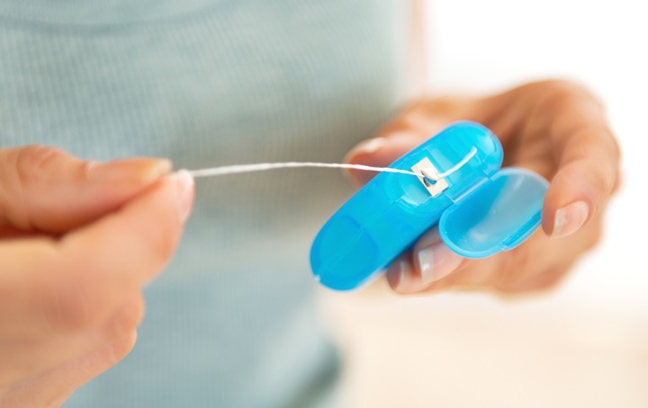 Person holding dental floss container