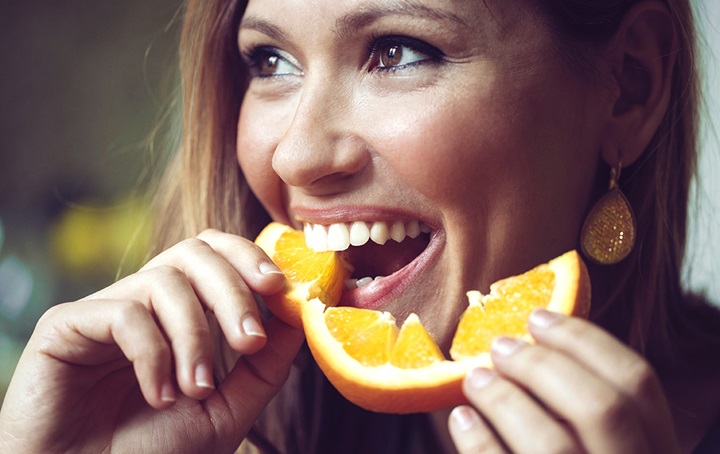 Woman thrilled to be eating orange