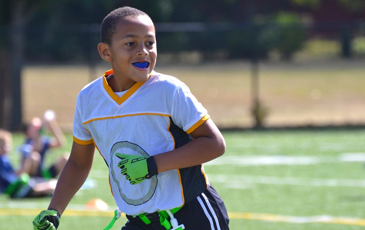 A young boy is wearing a mouthguard while playing sports.