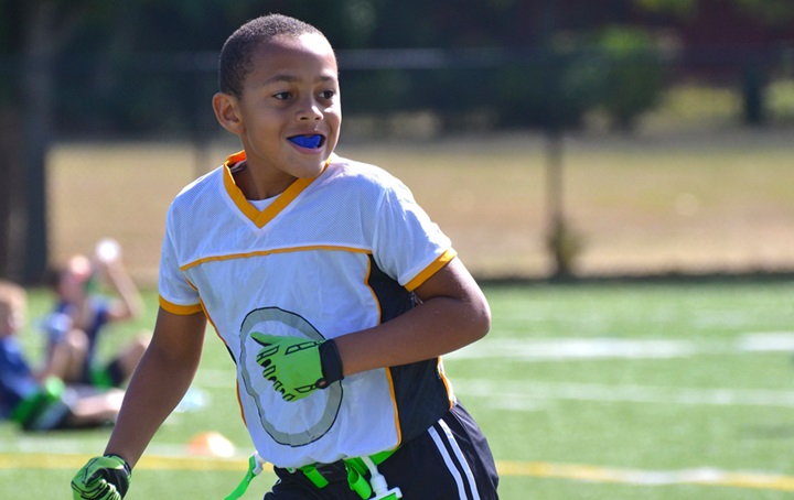 A young boy is wearing a mouthguard while playing sports.