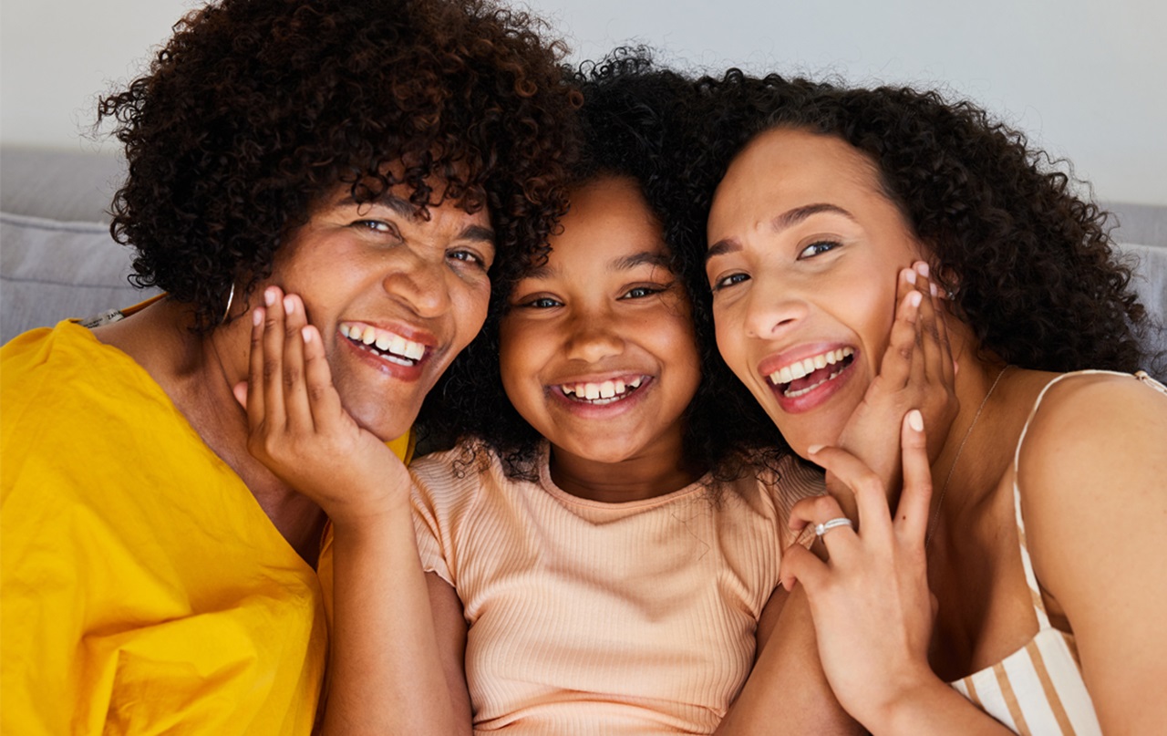 An image of 2 woman and a child smiling together