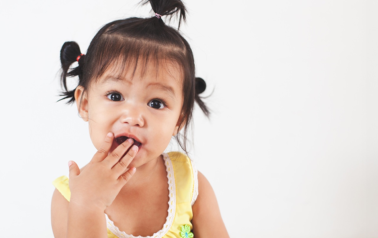 girl in pig tails with hand to her open mouth