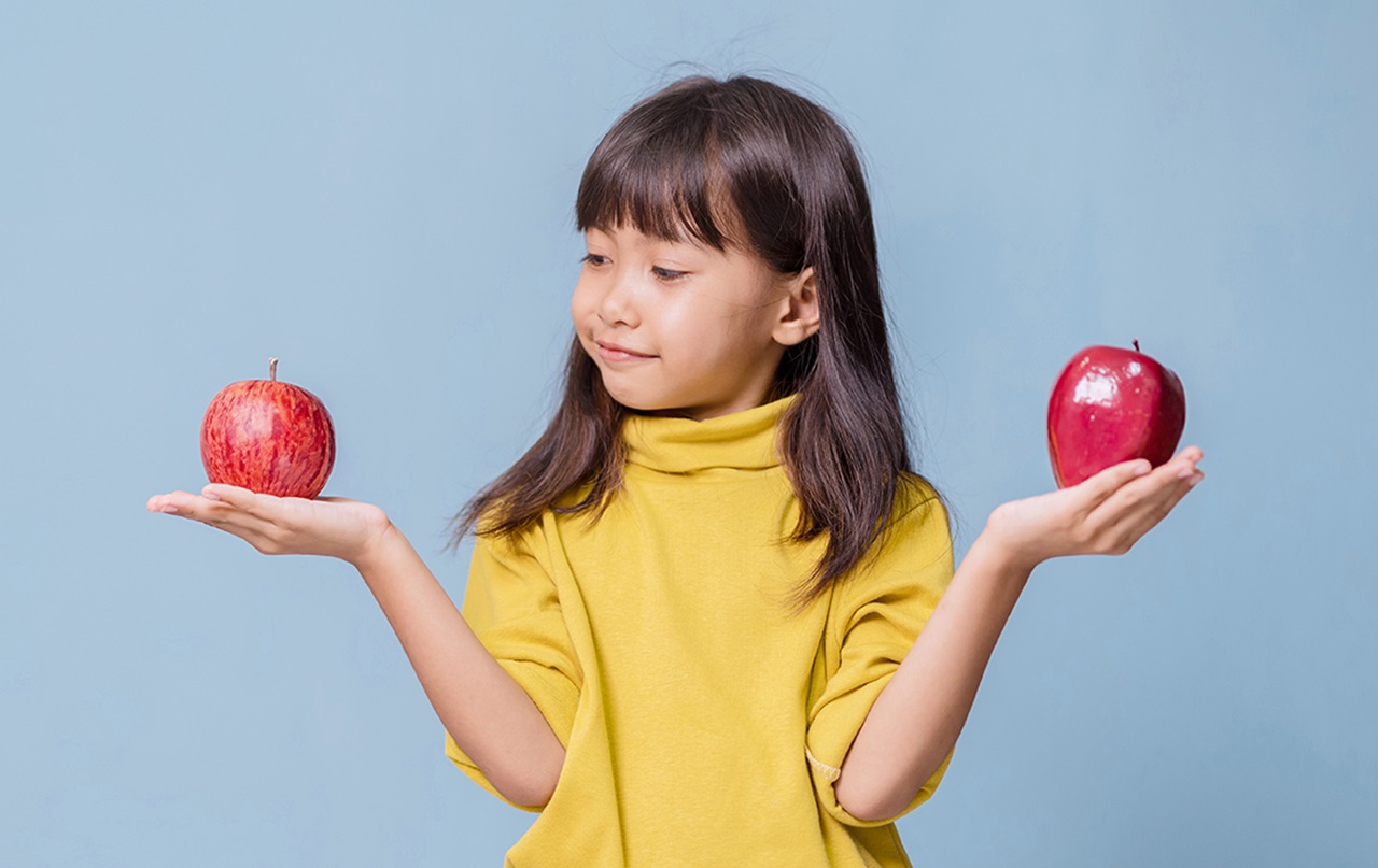 Child holding two apples