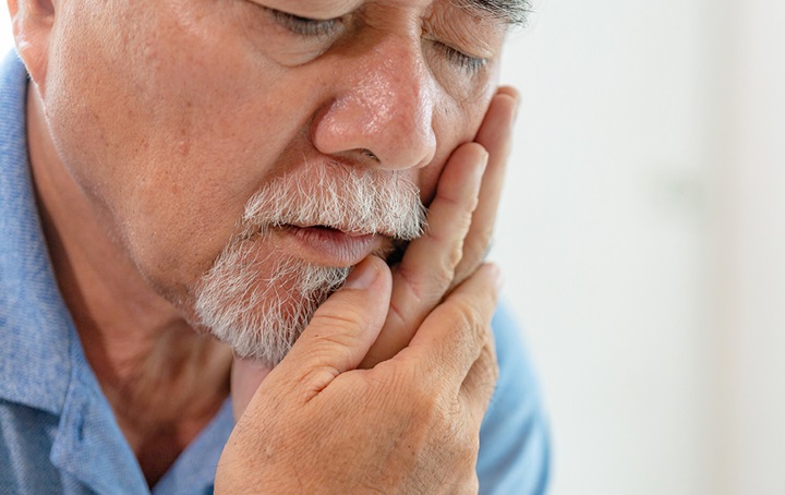 Man holding jaw with tooth pain