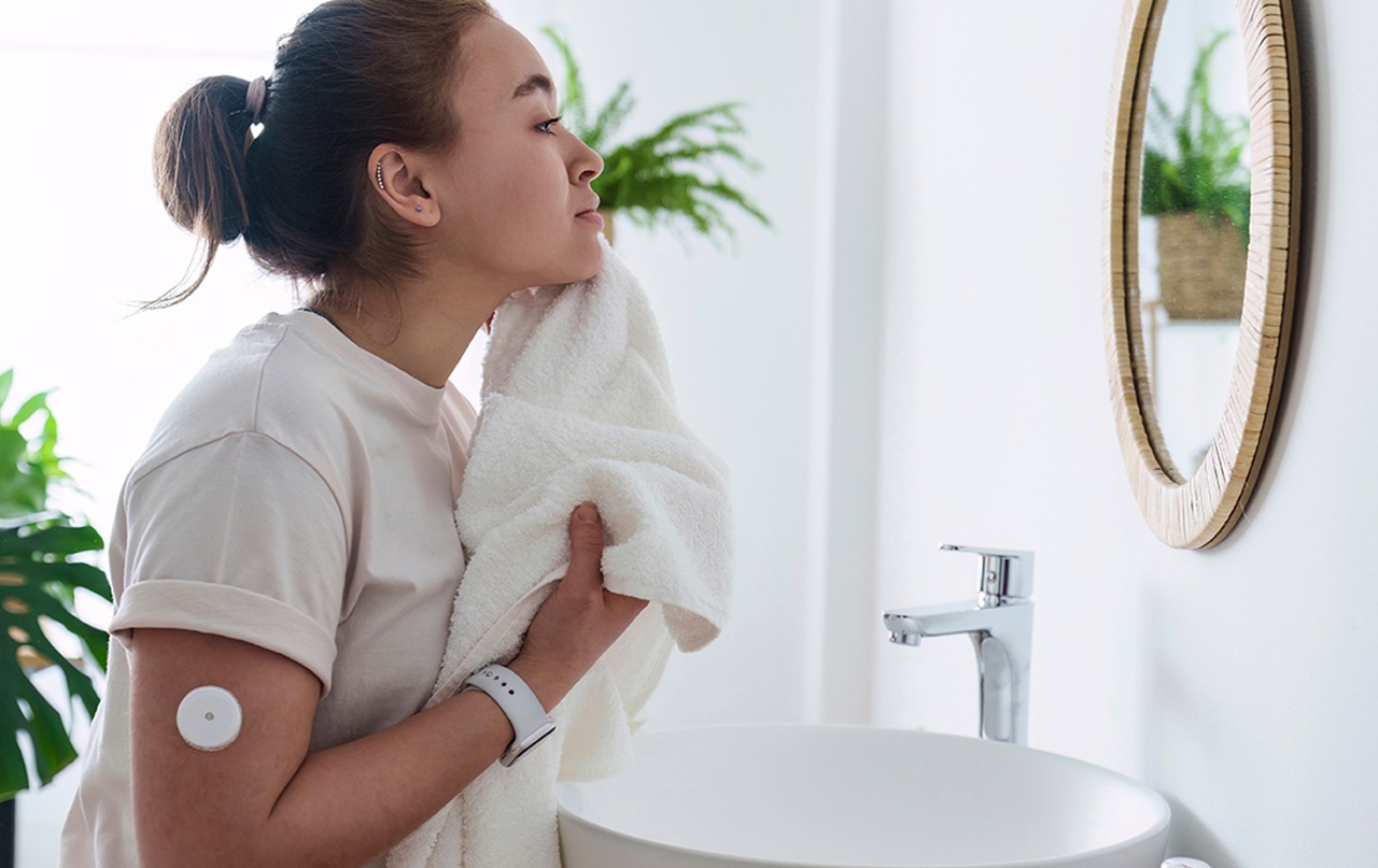 Woman that has diabetes monitor looking in mirror