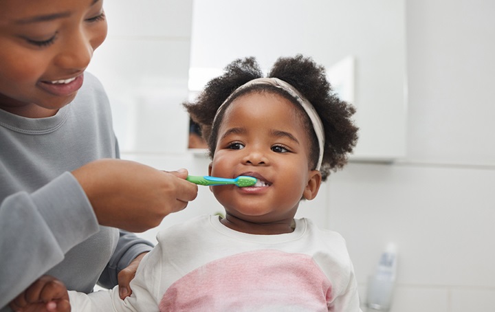 Mother brushing baby's teeth