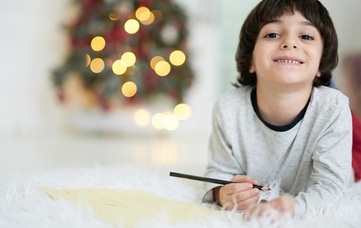 A young child, smiling and working on crafts for the holidays