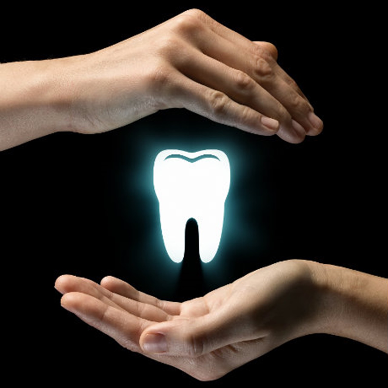 Two hands protecting a glowing white tooth.