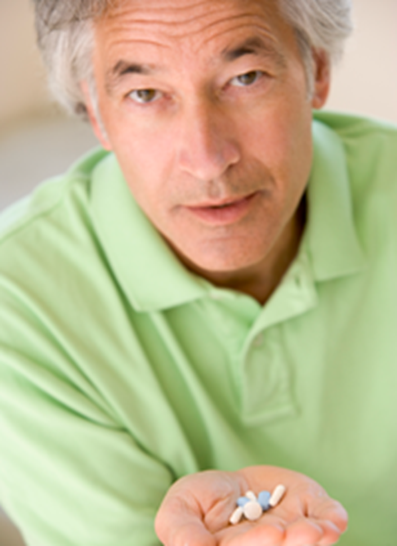 Image of man holding medications in open hand