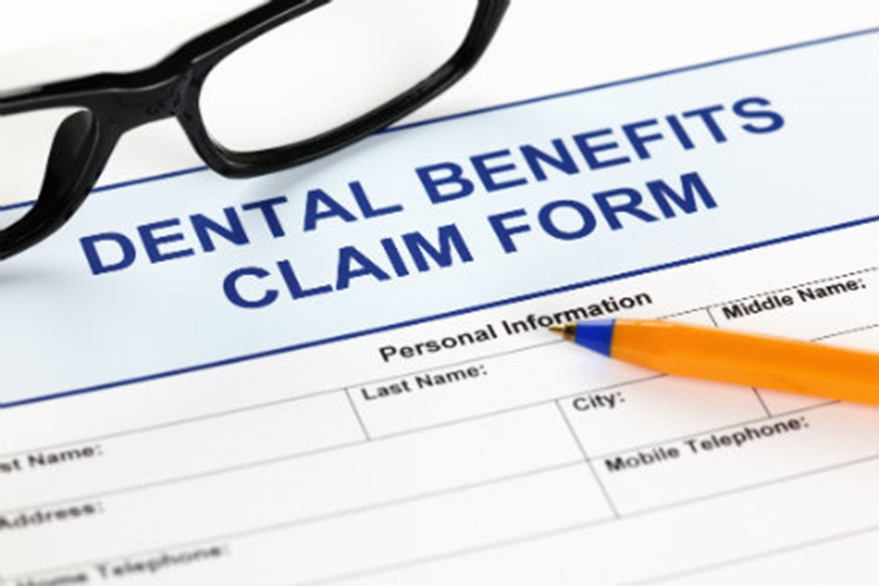 A dental benefits claim form with a pen.