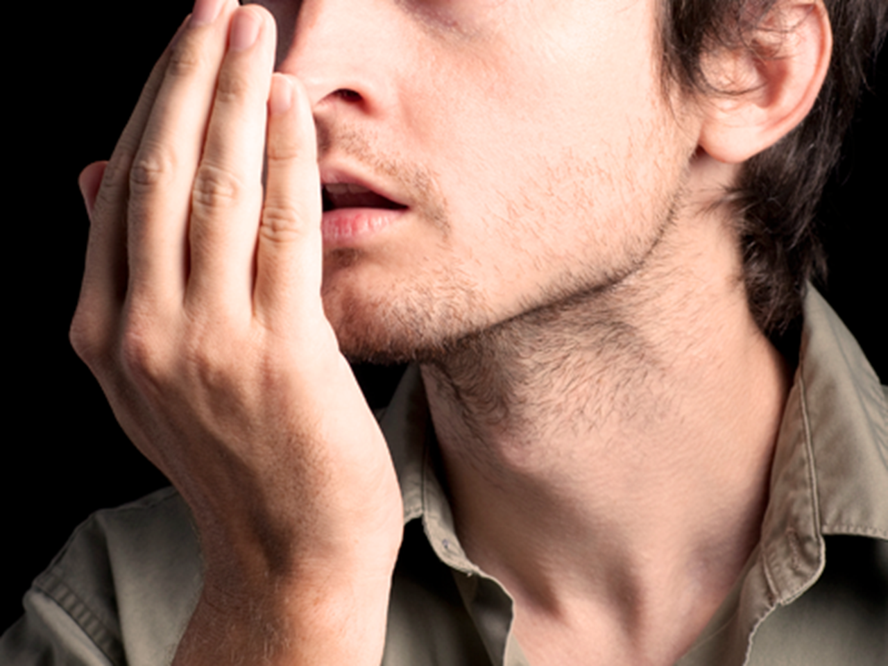Photo of man checking self for bad breath