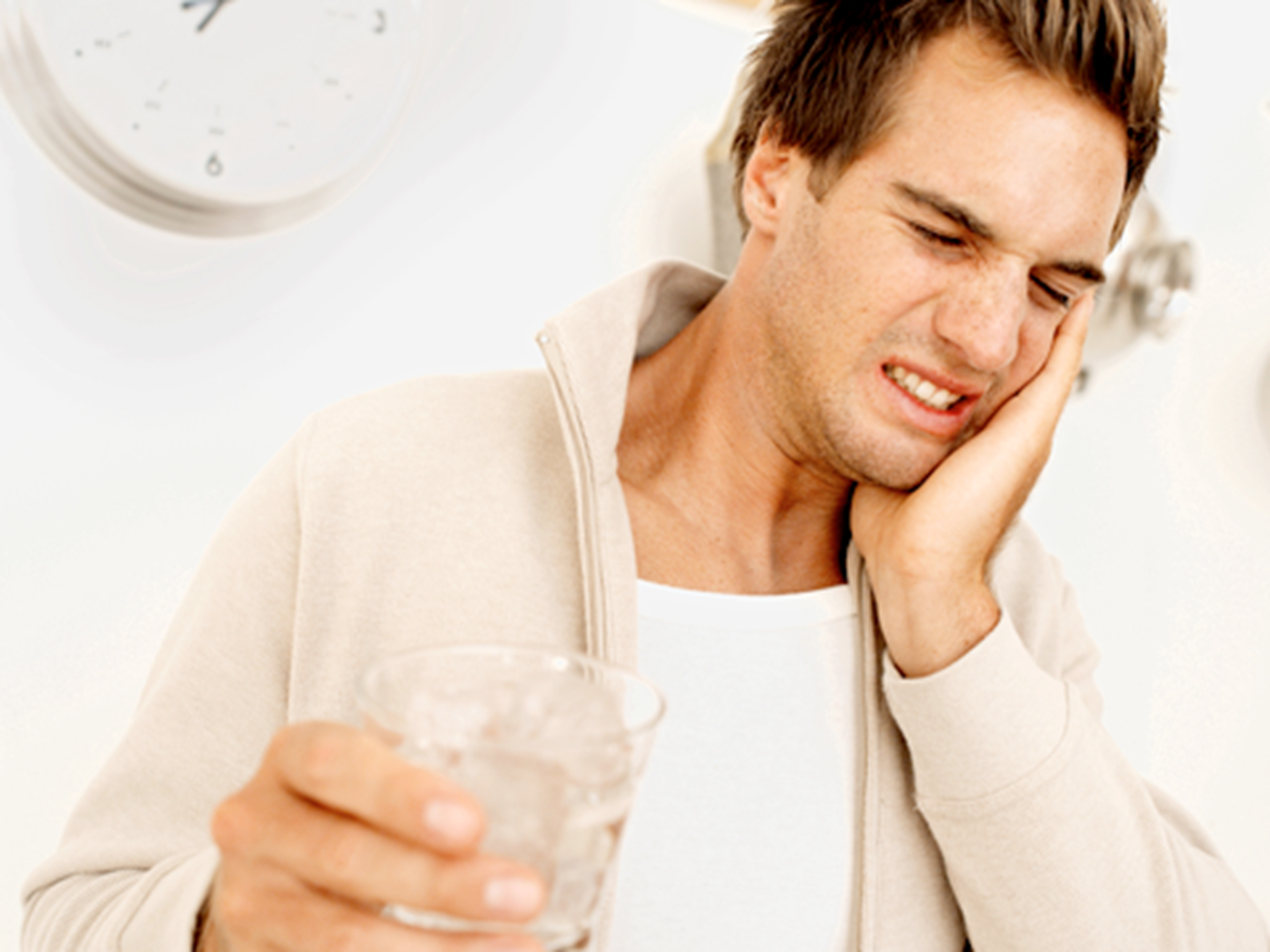 Young man grimacing after drinking ice water