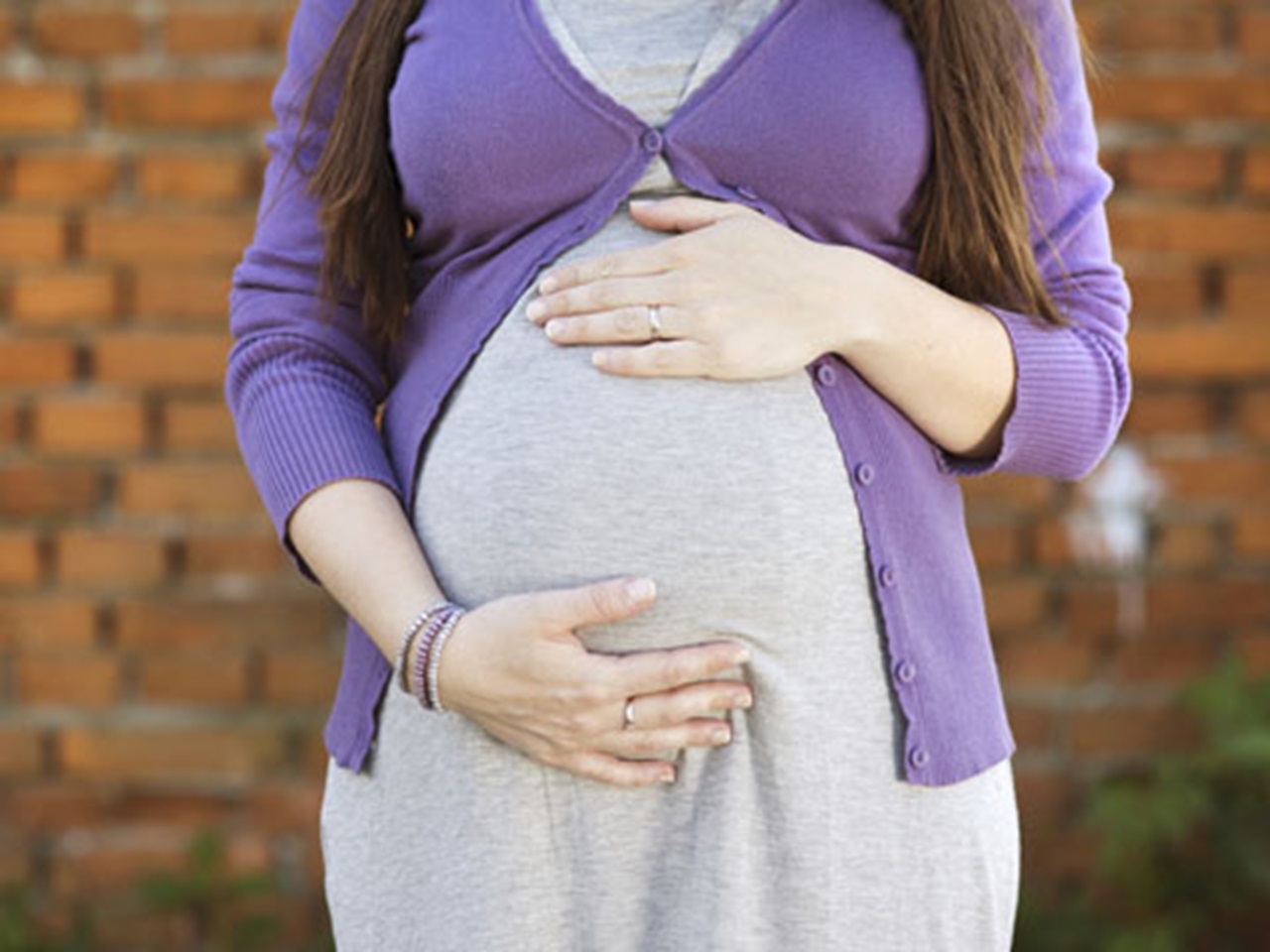 A pregnant woman holds her belly